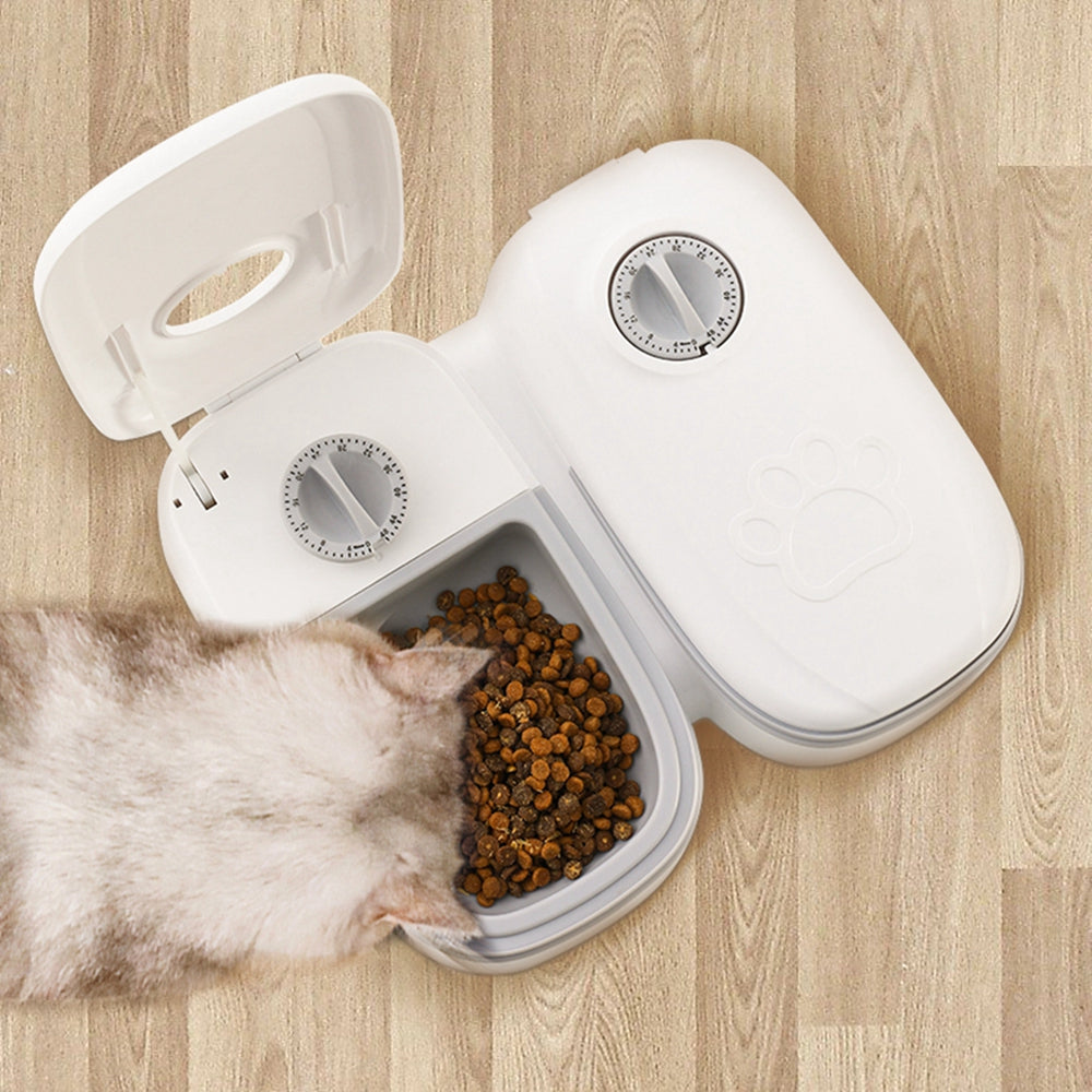 Smart automatic pet feeder by Nick's Super Store, no electricity needed, featuring a clear food container and feeding tray for pets.