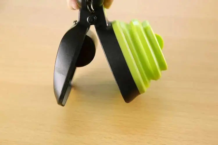 Blue foldable dog pooper scooper from Nick's Super Store with biodegradable bags for easy travel cleanup in one hand.